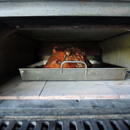 Das Spanferkel schmort im Ofen des neuen Backhäusles der Bauerntafel auf St. Barbara zirka sechs bis sieben Stunden bei 180°C. (Foto: Beate Kierey)